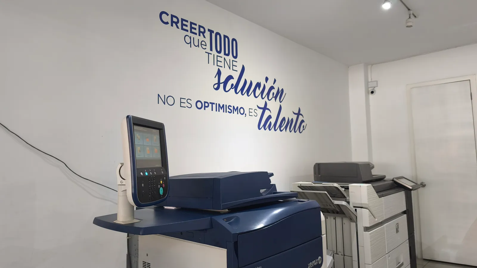 Muro interior con frase rotulada en vinil junto al área de máquinas