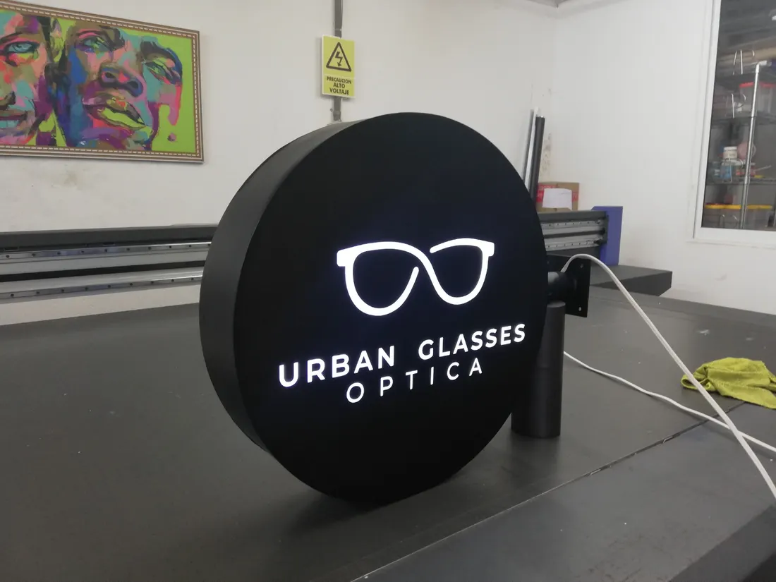 Caja de luz circular encendida con el logo de Urban Glasses Óptica