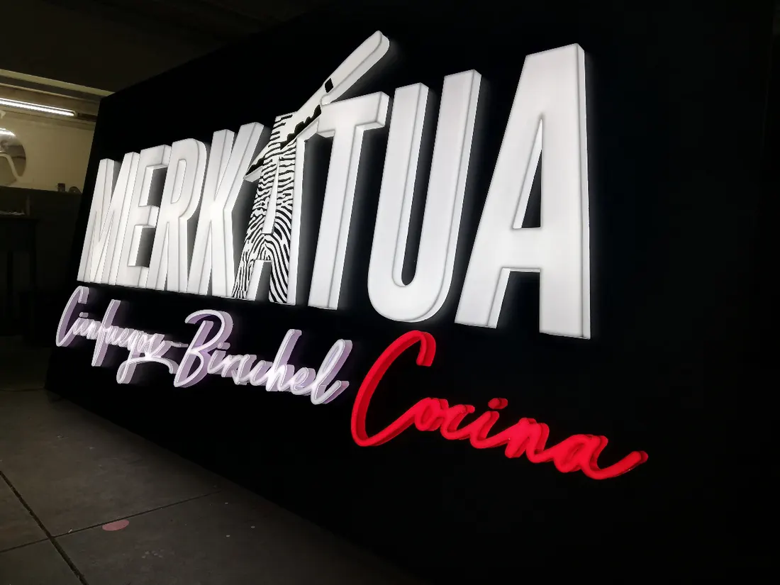Letras 3D iluminadas de Merkatua con texto en neón rojo